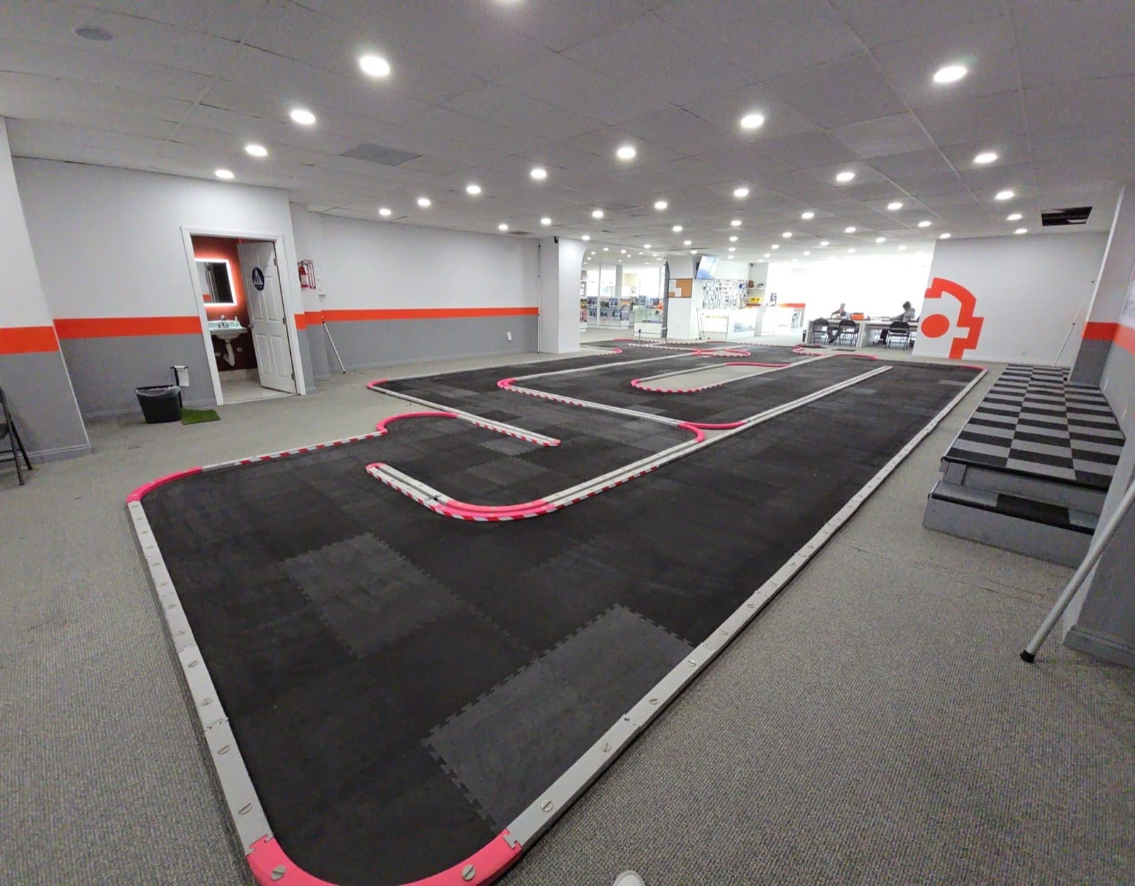 Custom RC race track inside Lawndale venue with drivers stand and live timing screen