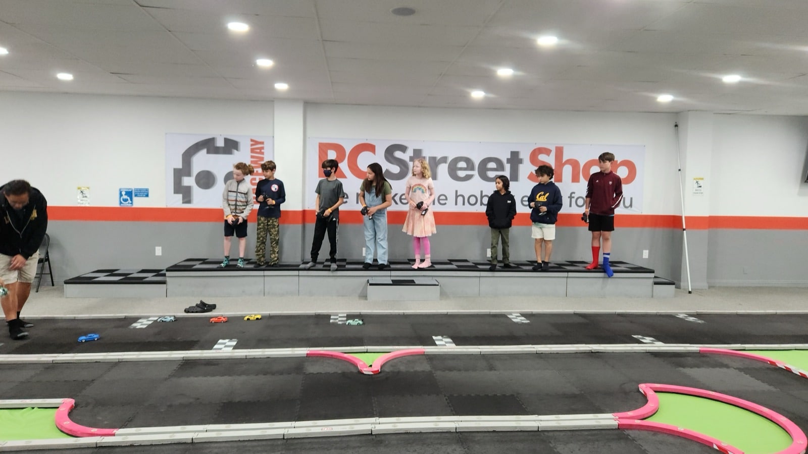 Kids racing RC cars on indoor track at birthday party