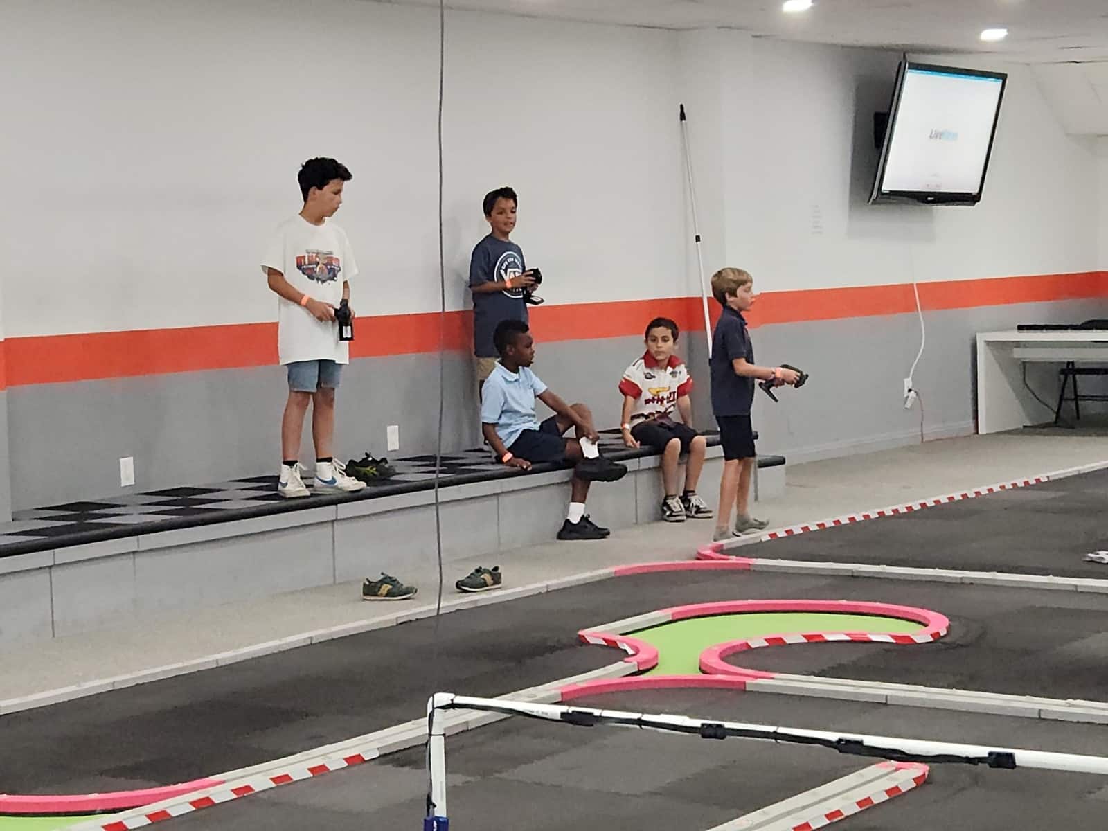 Young racers learning RC car control at the indoor track